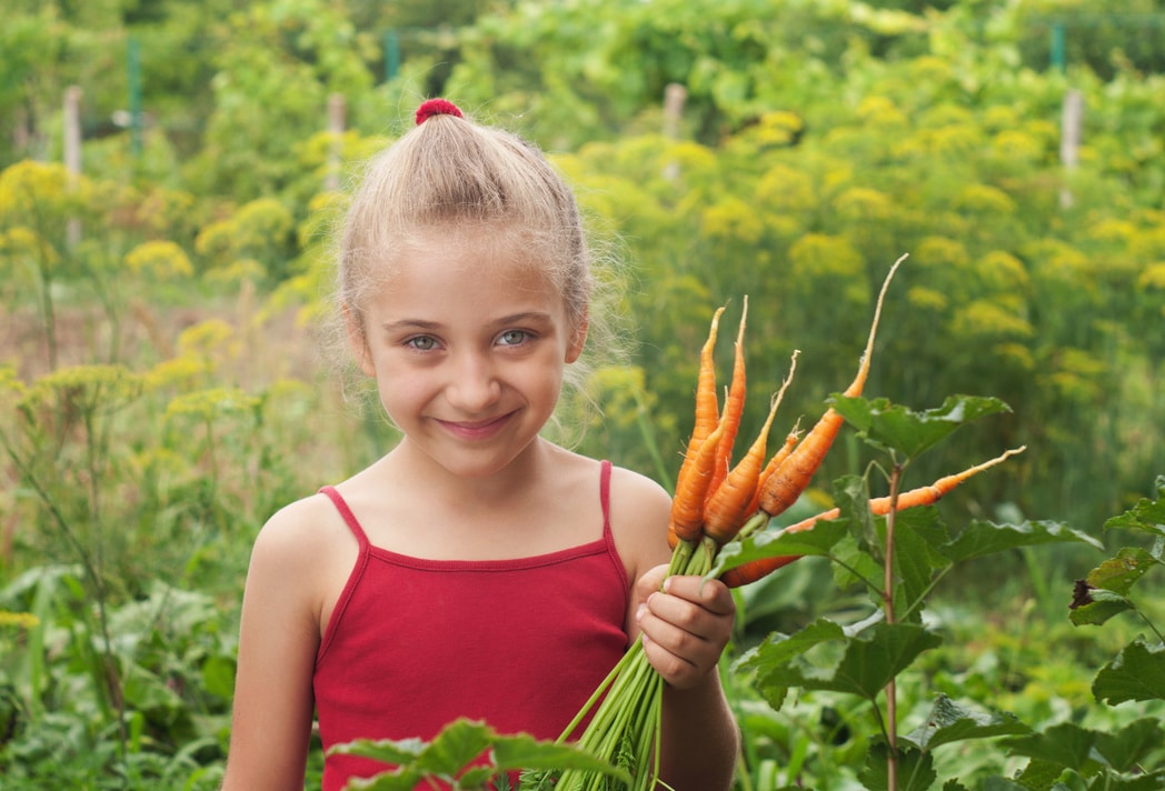 young girl working in vegetable garden