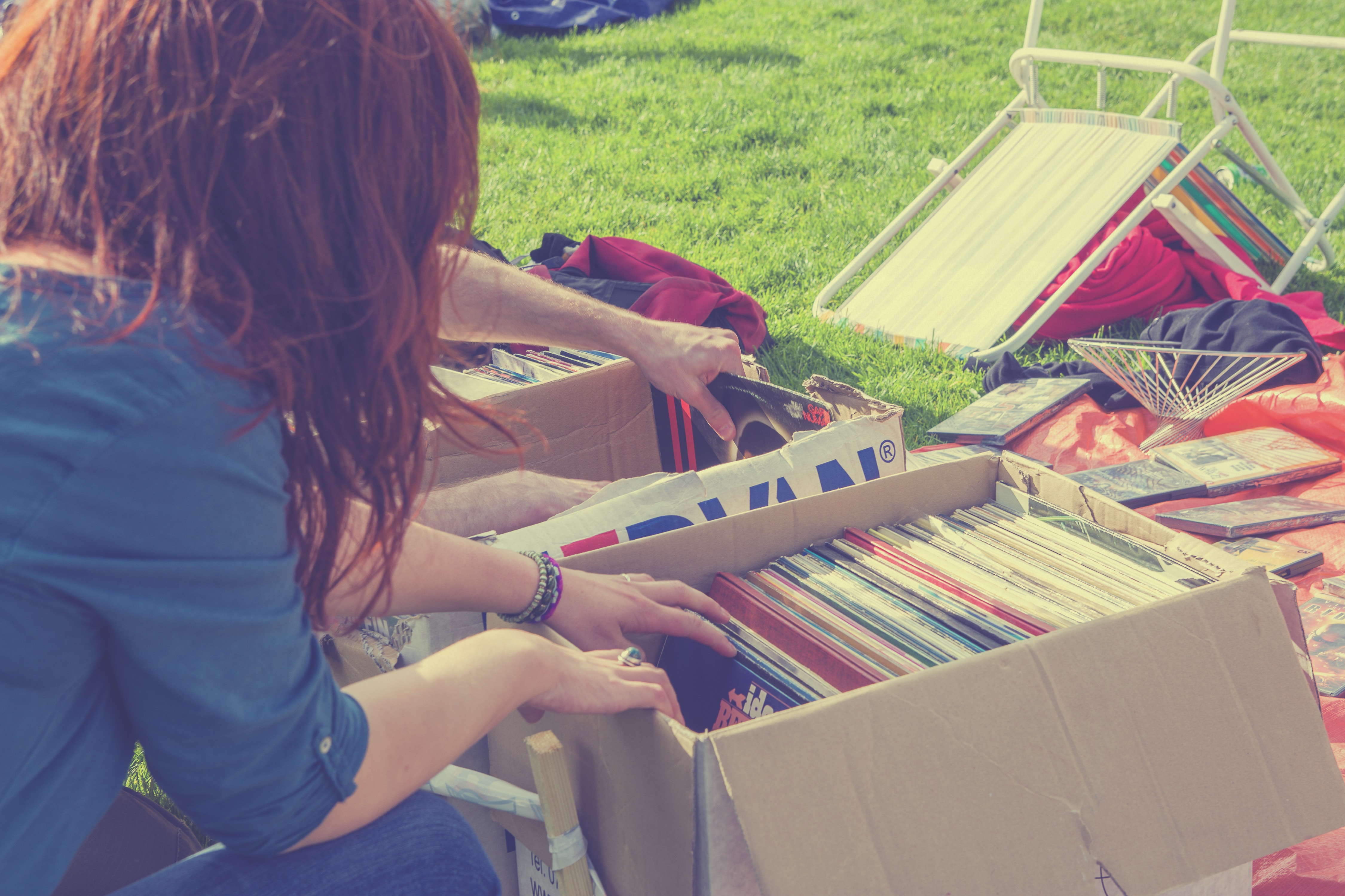 Young hipster girl browsing through second hand records in boxes on a free market in the Netherlands