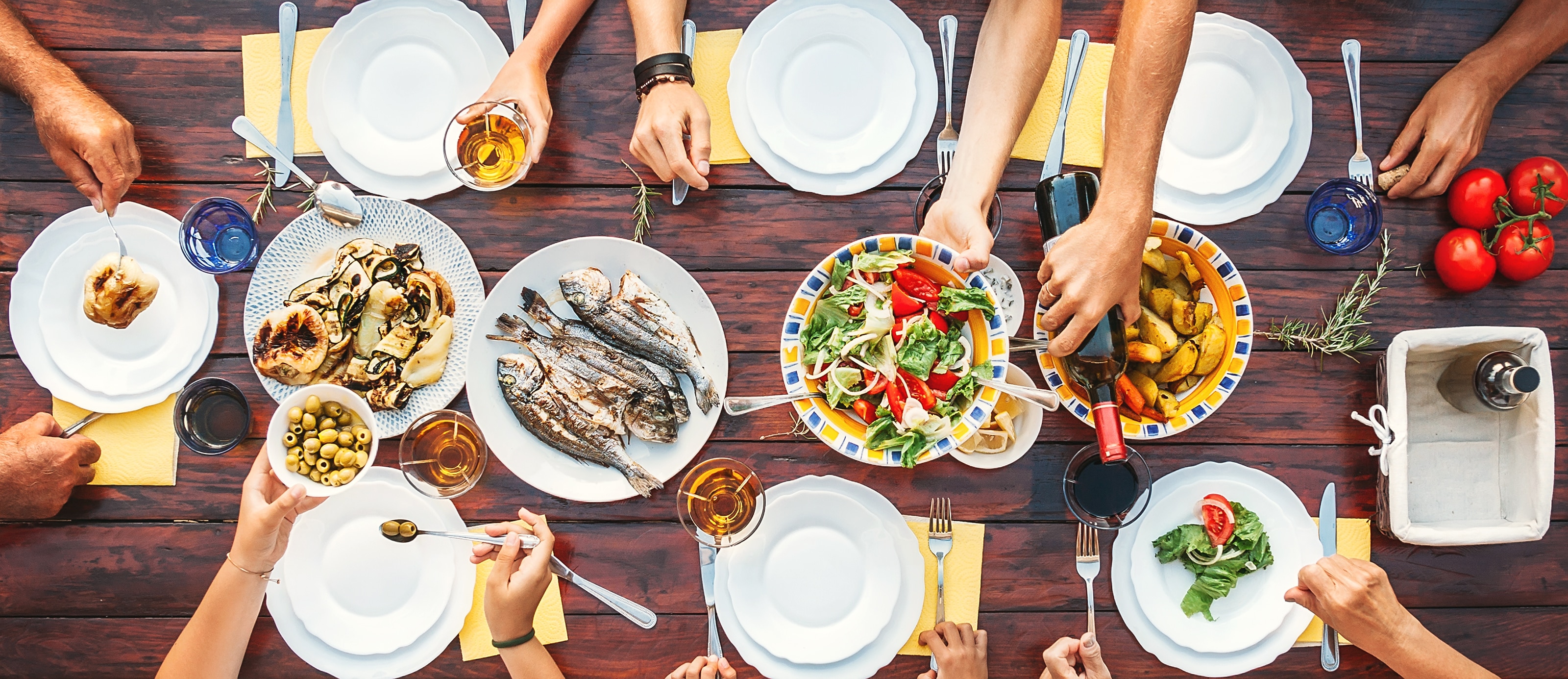 Big family dinner. Top vertical view on the table with dishes and hands