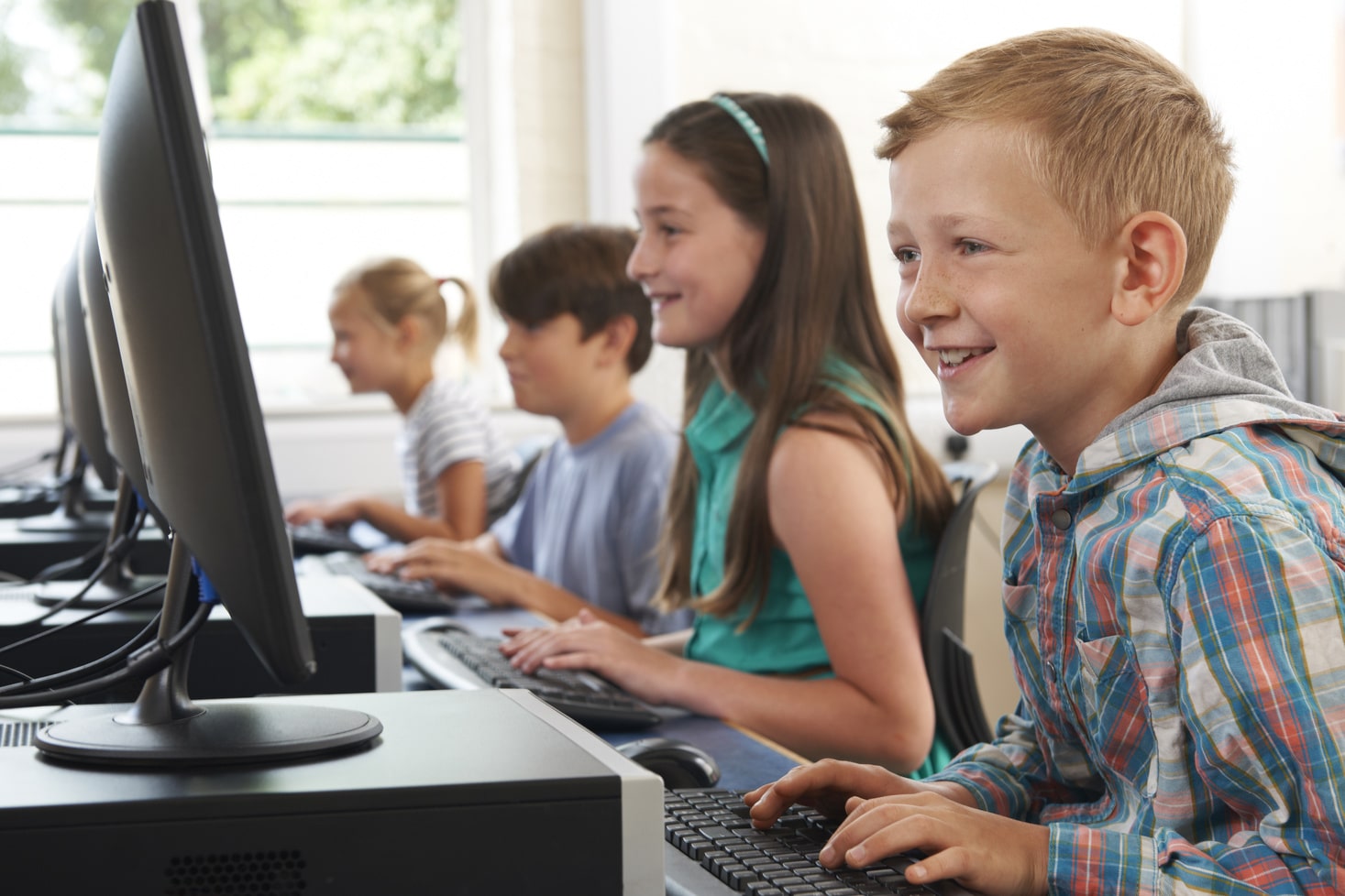 Group Of Elementary School Children In Computer Class