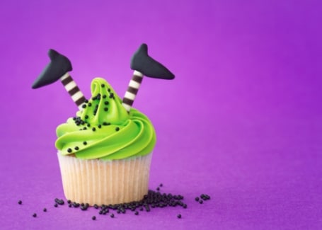 Green iced cupcake with witches legs and feet sticking out