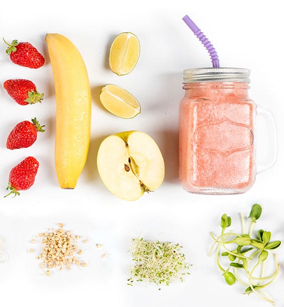 Detox cleanse drink, fruits and berries smoothie ingredients. Natural, organic healthy juice for weight loss diet or fasting day. Mason jar of dietary drink with strawberries, microgreens and banana.