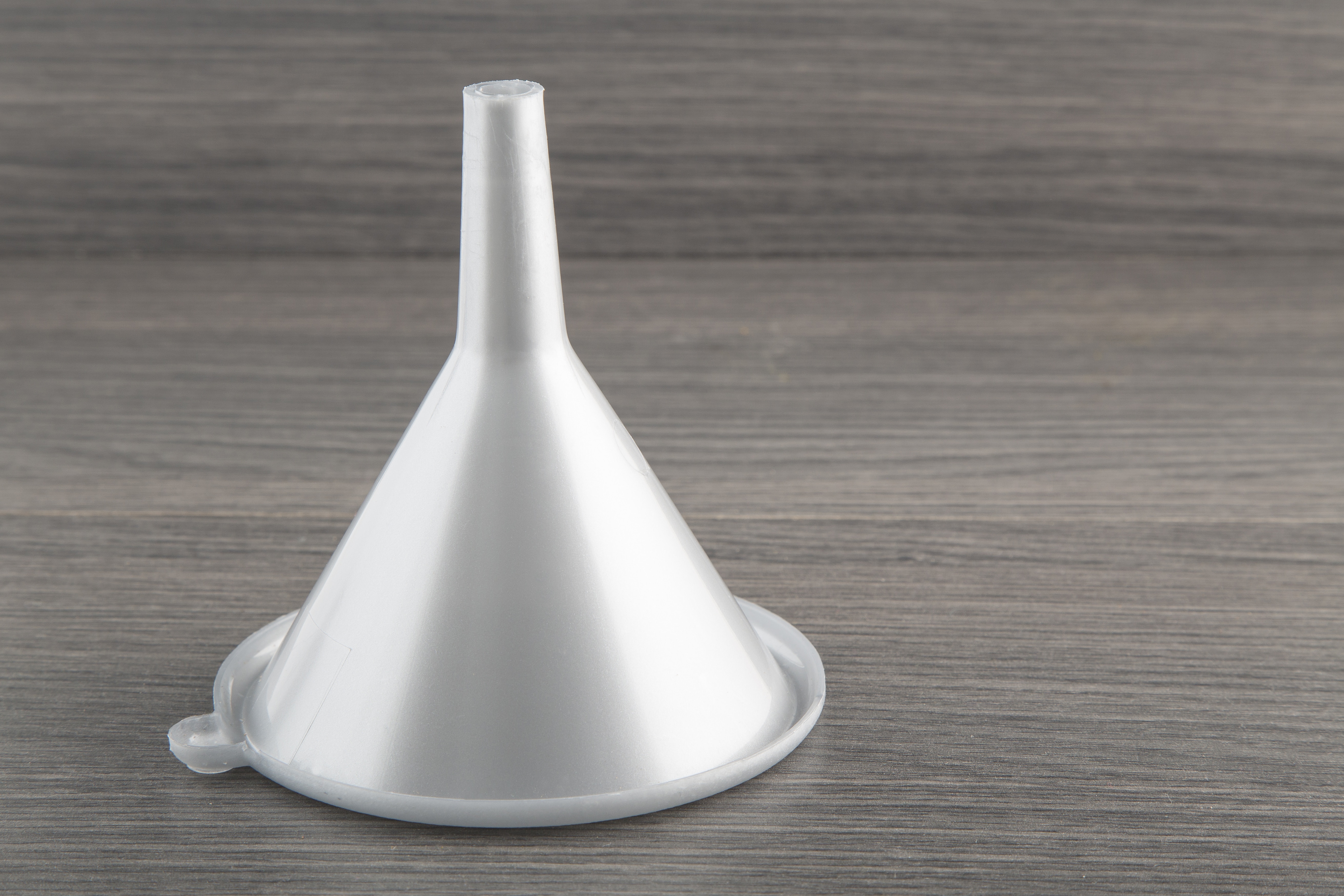 plastic funnel on wooden background