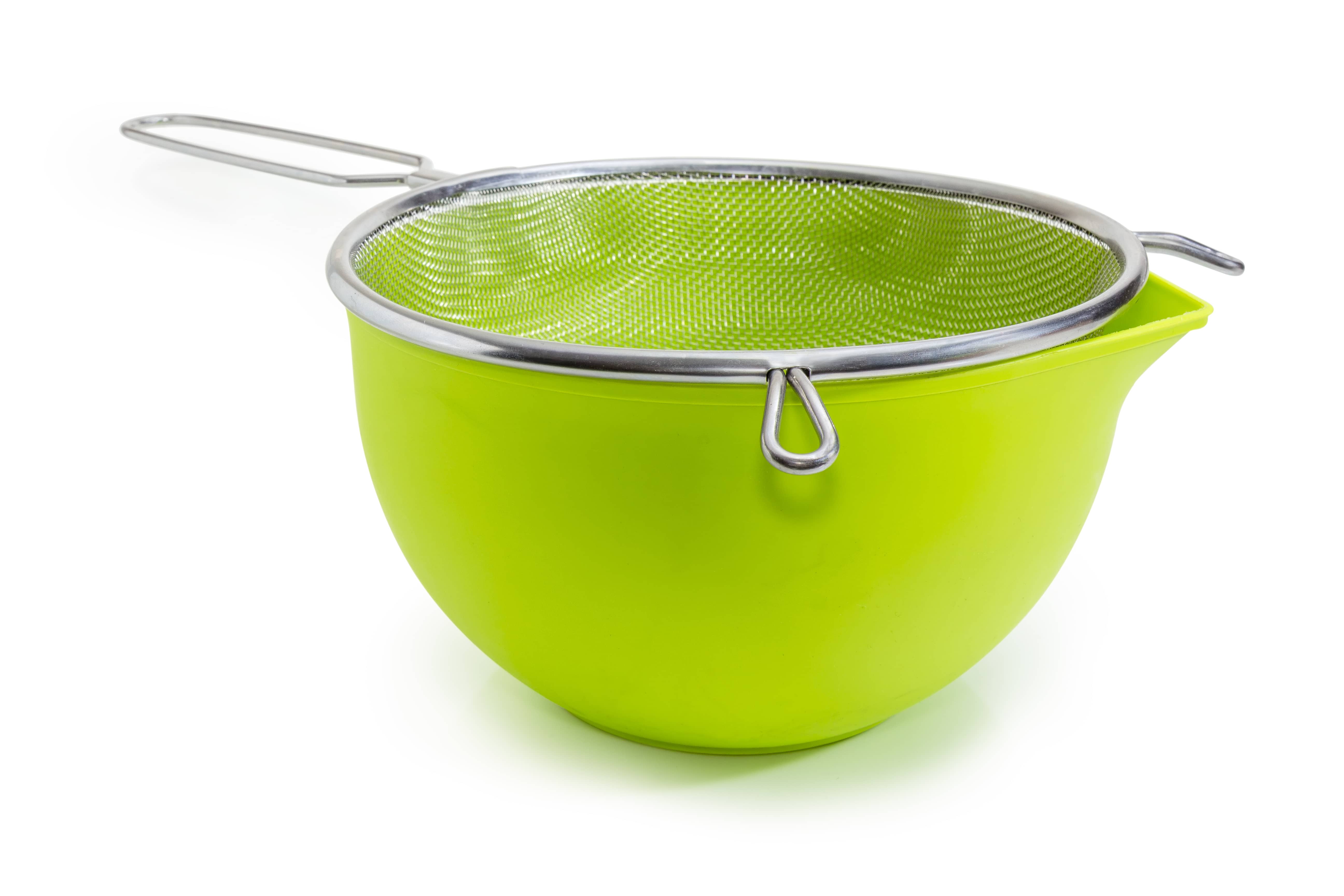 Green bowl and round stainless steel sieve with wire mesh at selective focus on a white background