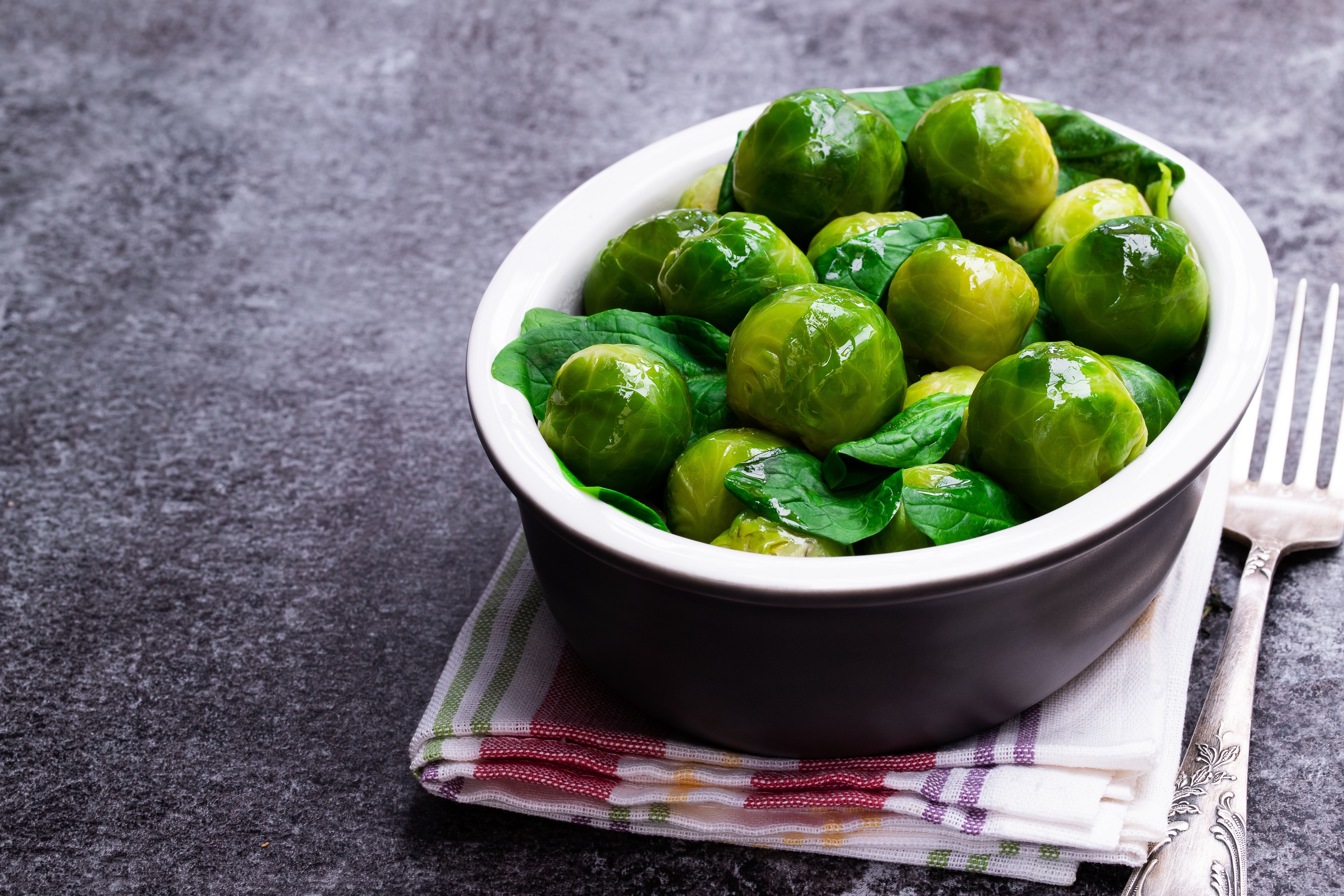 Cooked  brussels sprouts with spinach on gray table