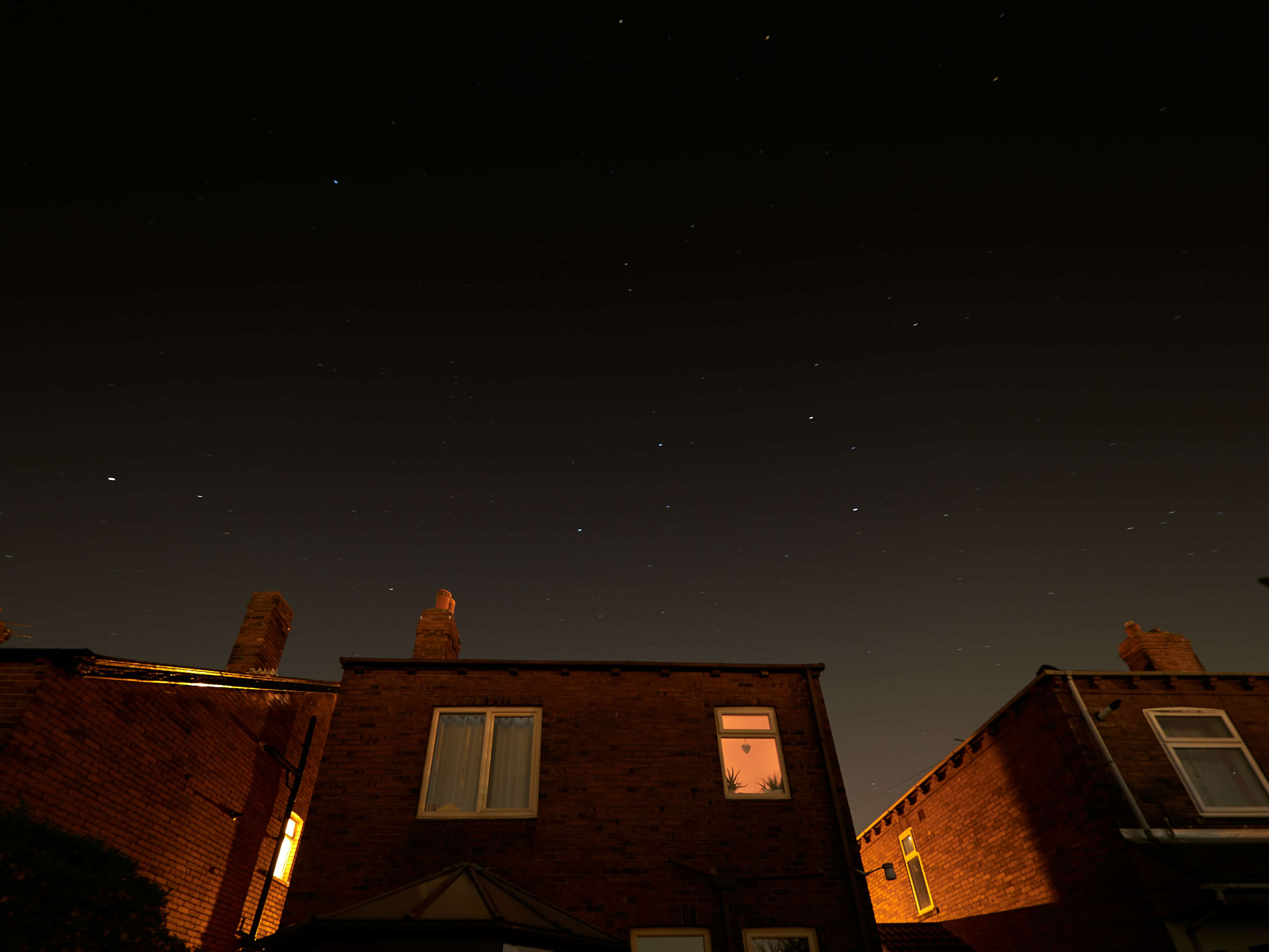 Stars sparkle clearly on a cloudless night over houses on a street in Wakefield, Yorkshire.