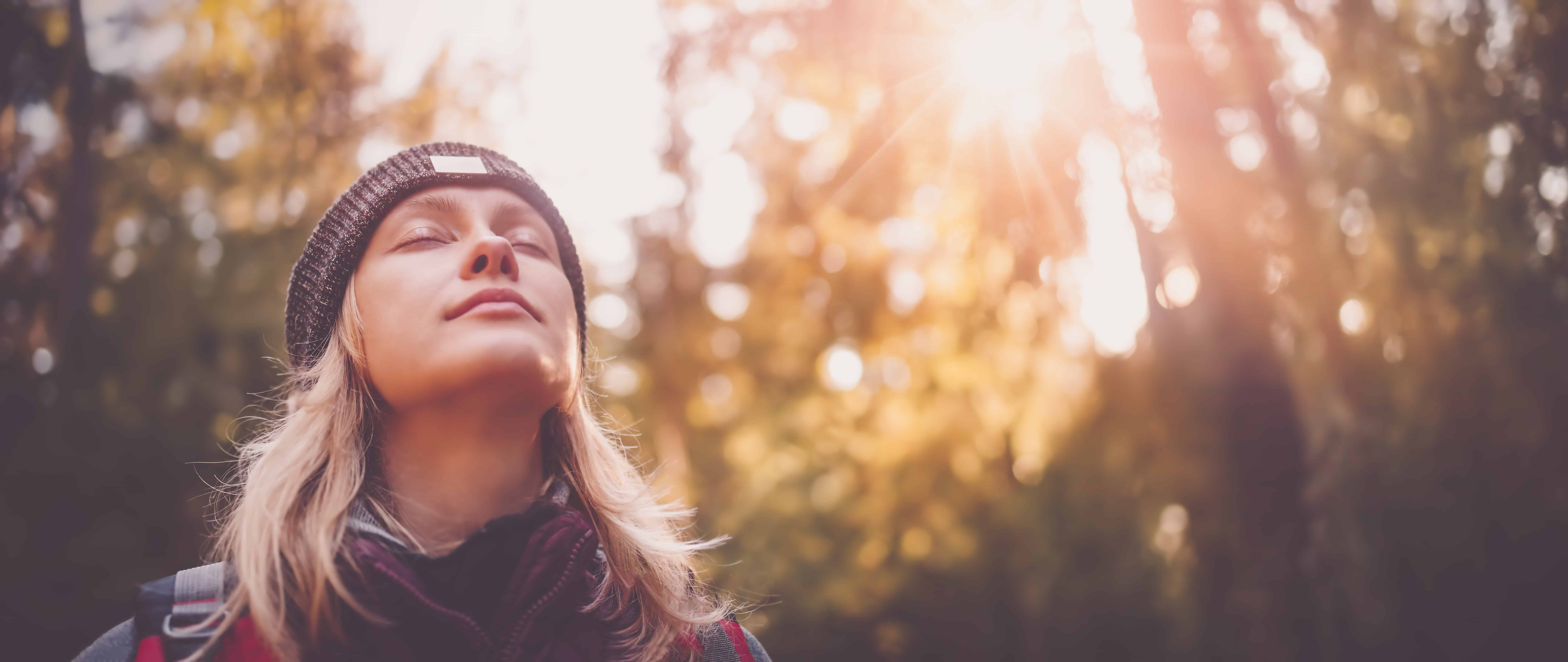 Young woman hiking and going camping in nature. Person with backpack walking in the forest