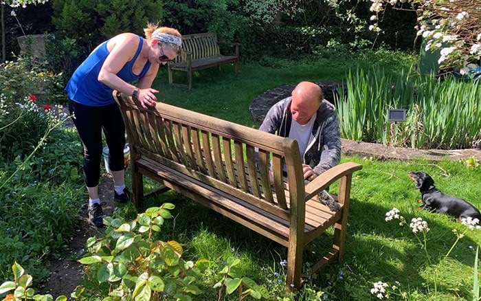 Two members of a community garden building a bench