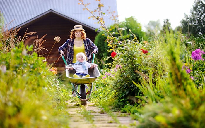 Mother wheeling her child in a wheelbarrow