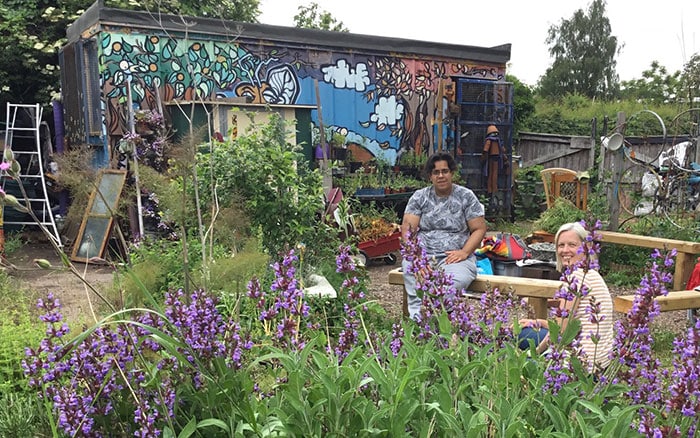 Mural and two people in a community garden